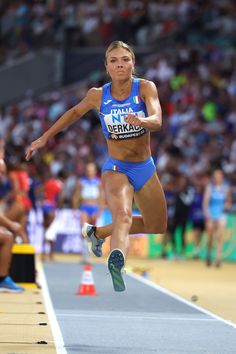 a woman is jumping in the air on a track