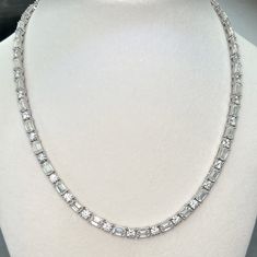 This is a DNS Jewelry exclusive in-house design with low profile open basket setting for enhanced sparkle, and our one of a kind spring loaded box clasp that does not fail over time like typical friction-style clasps. This dazzling tennis necklace looks beautiful and elegant, and will never go out of style. Perfect for a beautiful evening out.  Moissanite offers timeless beauty and exceptional value. The stones we use are GRA certified VVS1 clarity Moissanite. The details matter so we do not buy Diamond White Tennis Necklace With Baguette Diamonds, Luxury Baguette Cut Solitaire Necklace, Diamond White Cubic Zirconia Tennis Necklace With Baguette Diamonds, Diamond White Baguette Cubic Zirconia Tennis Necklace, Elegant Diamond Tennis Necklace With Baguette Diamonds, Fine Jewelry Diamond Tennis Necklace With Baguette Diamonds, Formal Diamond White Tennis Necklace With Baguette Diamonds, White Gold Diamond Tennis Necklace With Baguette Cut, Luxury Baguette Cut Solitaire Necklace For Anniversary