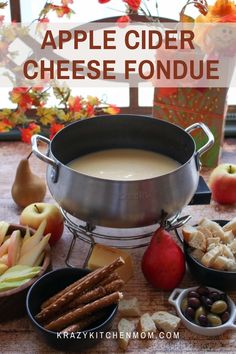 an apple cider cheese fondue surrounded by apples and other snacks