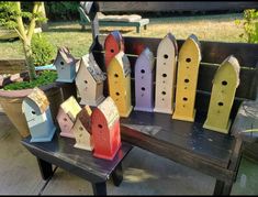 colorful bird houses are sitting on a bench