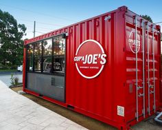 a red shipping container sitting on the side of a road