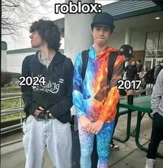 two young men standing next to each other in front of a building with the words roblox on it