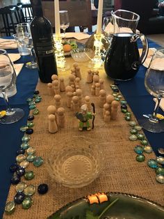 the table is set with wine bottles and figurines