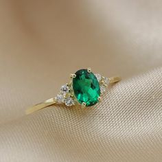 Vintage inspired diamond and emerald cluster ring.Set with a beautiful oval cut Green Emeralds and six sparkling diamonds.The ring has a dainty band so perfect for dainty ring lovers and stacking ring lovers.Could be a great alternative engagement ring or a unique everyday ring.Shown in photos in 14K Yellow gold size 6.5Made in all rings sizes, and in in 10K, 14K and 18K Gold.Handmade by artist in solid gold with an utmost attention to details.Beautifully finished with Each gemstone handpicked a Gold Emerald-cut Cluster Ring For Gift, Vintage Oval Emerald Ring Gift, Vintage Emerald Ring For Promise, May Birthstone, Green Emerald-cut Gemstone Cluster Ring, Yellow Gold Emerald Ring, Oval Cabochon Gift, Emerald Ring Vintage, Dainty Band, Aquamarine Jewelry, Everyday Rings