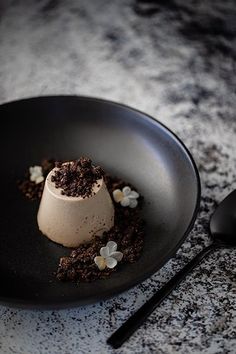 a black plate topped with a dessert on top of a table