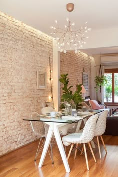 a dining room table and chairs in front of a brick wall