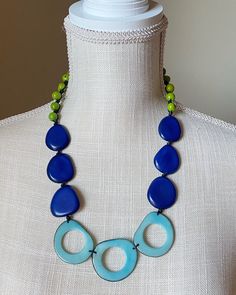 Everyone will notice your stand-out style in our Riviera Maya necklace. The bold combination of shapes and color creates a dynamic look that's perfect for any occasion. This stunning piece features tagua rings in sky blue, tagua beads in royal blue and green acai seeds.  Thanks to the natural characteristics you can be sure yours is unique. Tagua, also called the vegetable ivory is the seed of a palm tree that grows in the tropical rainforests of several South American countries including Colomb Blue Long Necklace For Party, Unique Blue Jewelry For The Beach, Handmade Bold Blue Jewelry, Bold Handmade Blue Jewelry, Blue Adjustable Long Necklace, Bold Blue Jewelry For Party, Unique Blue Necklace For Beach, Blue Long Necklace For Beach, Unique Blue Beaded Necklace For Beach