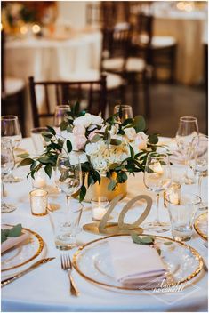 the table is set with white linens and place settings