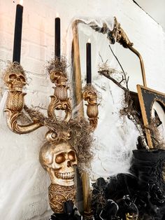 there is a gold skull on the wall next to some candles and other decor items