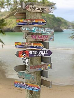 a wooden sign post with many different signs on it's side by the beach