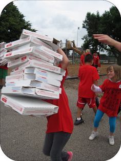 a group of people carrying boxes on top of each other