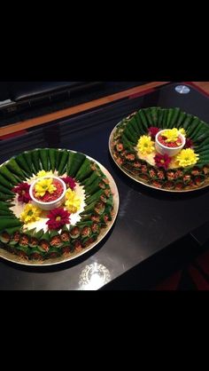 two plates with food on them sitting on top of a black table next to each other