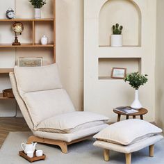 a living room with a chair and ottoman next to a book shelf filled with books