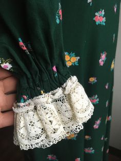 "1970s handmade prairie dress cotton w/lace trim zip up back ties below bust front to back long sleeve w/elastic wrist cuff dark green w/multi-color floral pattern very good vintage condition, light wear no size label tag (measures like xs/s but please go by measurements) measures, lying flat, shoulder-14 1/2\" bust-16 1/2\" waist-14\" hip-22 1/2\" sleeve-23\" length-51\"" Green Lace Trim Dress For Fall, Stretch Cotton Dress With Lace Trim, Vintage Spring Dresses With Smocked Cuffs, Vintage Dresses With Smocked Cuffs For Spring, Spring Vintage Dresses With Smocked Cuffs, Long Sleeve Cotton Dress With Lace Cuffs, Fitted Long Sleeve Dress With Crochet Trim, Vintage Cotton Dress With Lace Cuffs, Cocktail Dress Vintage