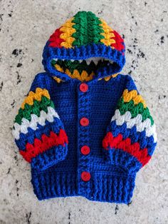 a crocheted blue jacket with multicolored stripes on the sleeves and hood