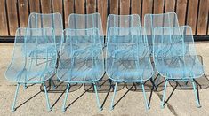 six blue metal chairs sitting next to each other