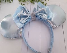 a blue minnie mouse ears headband with silver sequins and a light blue bow