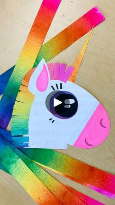 a paper cut out of a rainbow colored horse with an eye on it's forehead