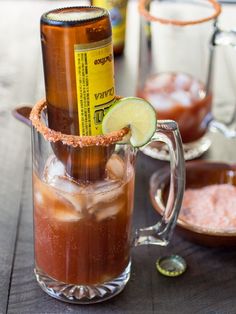 two glasses filled with cold drinks on top of a wooden table