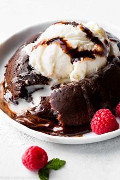 a white plate topped with chocolate ice cream and raspberries