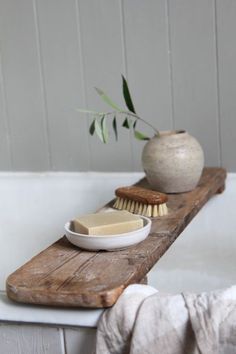 a white bowl and brush sitting on top of a bath tub