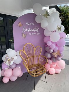 there is a chair and balloons in front of the sign