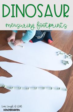 a child is making a dinosaur craft with white paper and green lettering on the bottom