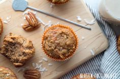 a wooden cutting board topped with muffins and pecans