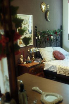 a bed room with a neatly made bed next to a dresser and mirror on the wall