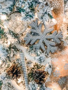 snowflakes and pine cones are hanging on the christmas tree