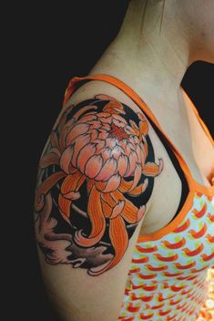 a woman with an orange and black tattoo on her arm