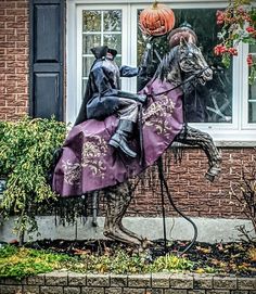 a statue of a man riding on the back of a horse next to a pumpkin