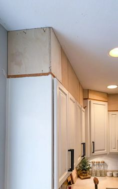 an unfinished kitchen with white cabinets and counter tops