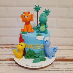 a birthday cake decorated with dinosaurs and plants