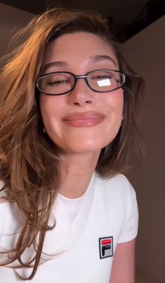 a woman with glasses is smiling for the camera