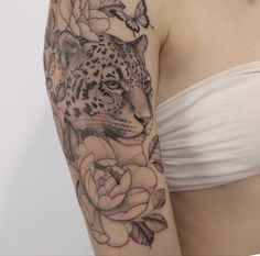 a woman's arm with a leopard and roses tattoo on the left side of her body