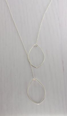 This Leaf Lariat Necklace creates several different looks! The 'leafs' can be placed close together or further apart and best of all, it has no clasp! You just simply place the chain around your neck and slide one leaf through the other and adjust into place. Done! (A little hint....If you loop the leaf through the other one twice, it will not slide as you move around). Each leaf is hand formed (approx. 2 inches in length) and hammered for strength and shine. This necklace is available in 14K Go Adjustable Teardrop Lariat Necklace, Adjustable Teardrop Pendant Drop Necklace, Adjustable Teardrop Lariat Necklace With Delicate Chain, Adjustable Teardrop Minimalist Lariat Necklace, Dainty Silver Teardrop Lariat Necklace, Silver Teardrop Lariat Necklace With Adjustable Chain, Adjustable Dangle Lariat Necklace For Layering, Adjustable Drop Lariat Necklace, Sterling Silver Adjustable Drop Necklace With Delicate Chain