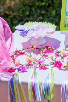 the table is decorated with flowers and ribbons for an outdoor birthday party or baby shower