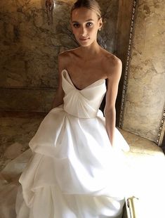 a woman in a white wedding dress posing for the camera