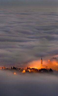 the city is surrounded by fog and low lying clouds