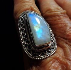 "Vintage Rainbow Moonstone Ring is a Large Best Quality Moonstone with Aqua, Indigo, and Gold Flashes Throughout, in a Bali Sterling Silver Ring, Size 7 It is bezel set in a solid sterling silver beautiful lacy pattern Bali style ring. Spectacular aqua, cobalt and indigo blue colors plus a beautiful gold streak in the middle flash brightly throughout the entire rainbow moonstone, and they seem to float throughout the almost clear freeform shaped gem. This is an especially beautiful clear and ver Fusion Style Oval Moonstone Ring Gift, Oval Moonstone Fusion Ring Gift, Fusion Style Moonstone Gemstone Ring For Anniversary, Fusion Style Anniversary Moonstone Gemstone Ring, Anniversary Fusion Style Moonstone Gemstone Ring, Anniversary Fusion Style Moonstone Ring, Fusion Style Oval Moonstone Ring, Fusion Style Oval Moonstone Ring For Anniversary, Handmade Fusion Moonstone Ring