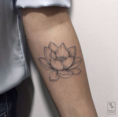 a black and white photo of a lotus flower tattoo on the right arm, with an inking technique