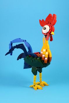 a lego chicken standing on top of a blue surface