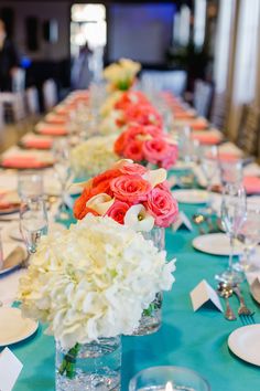 a long table is set with flowers and place settings