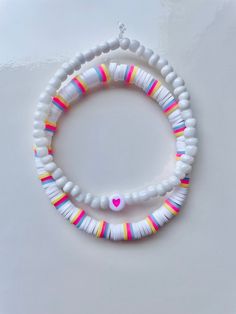 two bracelets with white beads and pink heart on the front, one is made out of