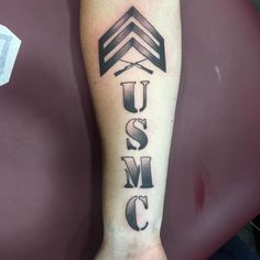 a man's arm with the word usm on it and an arrow tattoo