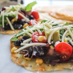 two flatbreads topped with vegetables and cheese