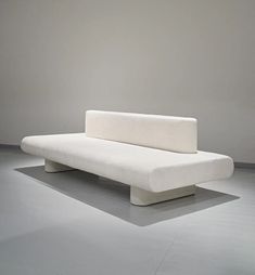 a white couch sitting on top of a gray floor