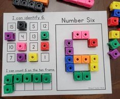 the number six is made out of legos and placed on top of a paper