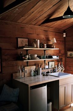 a kitchen with wooden walls and shelves filled with dishes